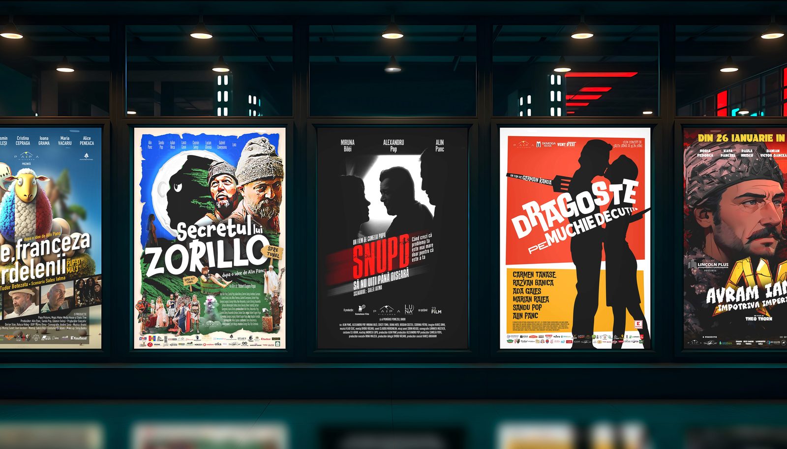 Un șir de afișe de film luminate din spate, în holul unui cinema