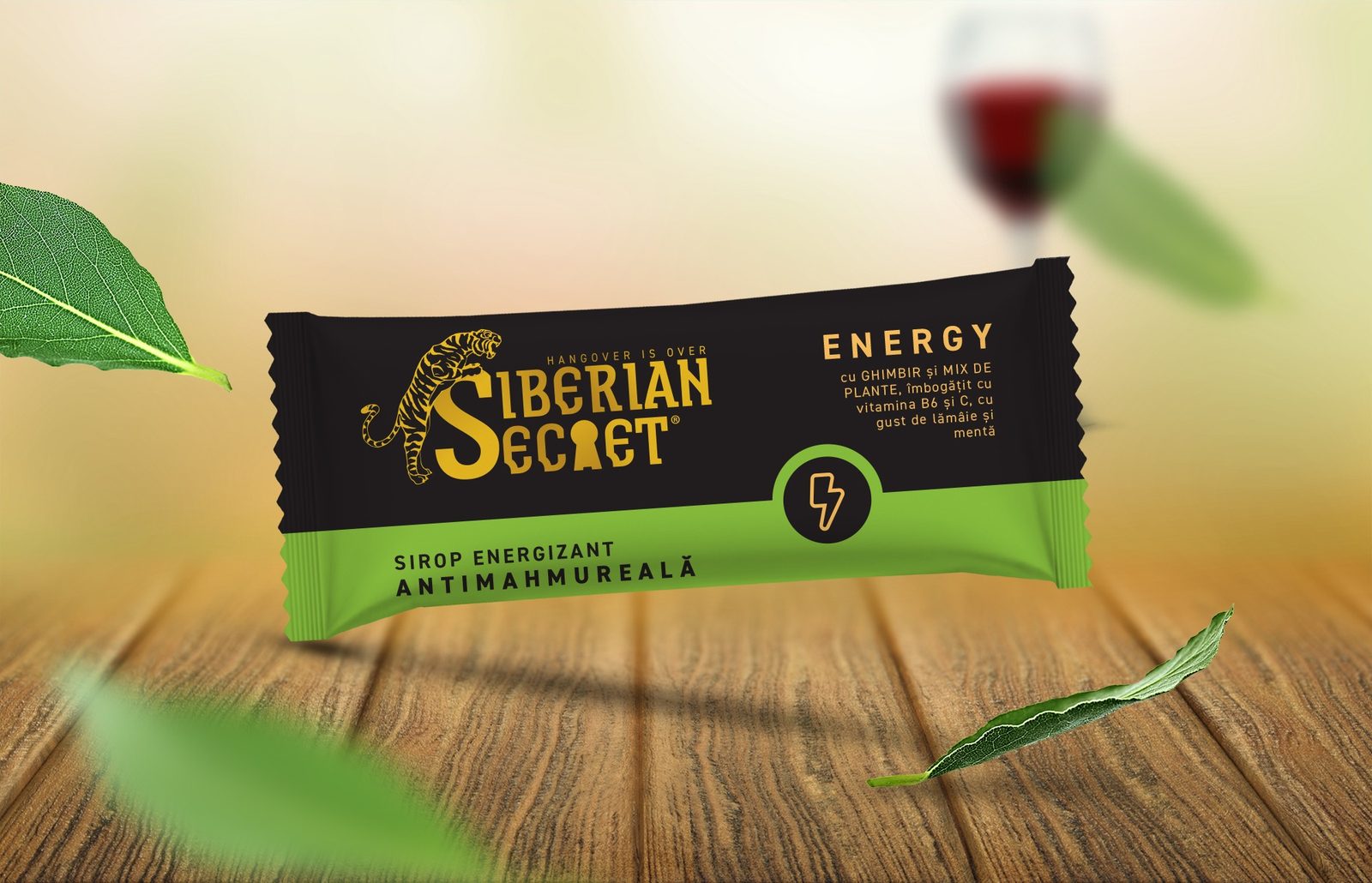 Un plic de sirop energizant Siberian Secret, pe lemn, lângă o frunză